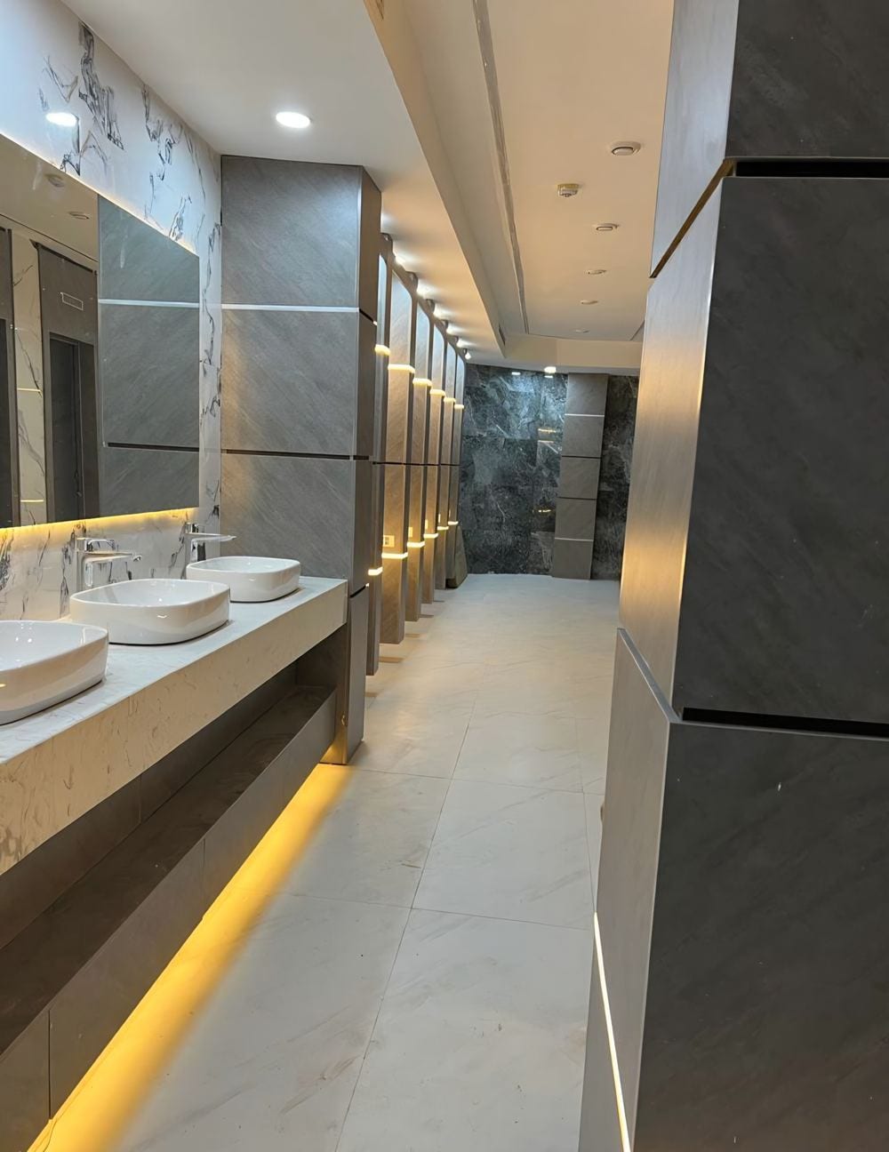 Luxury washroom fit-out — marble counters, vessel sinks, gold LED lighting by 3A Design Solutions